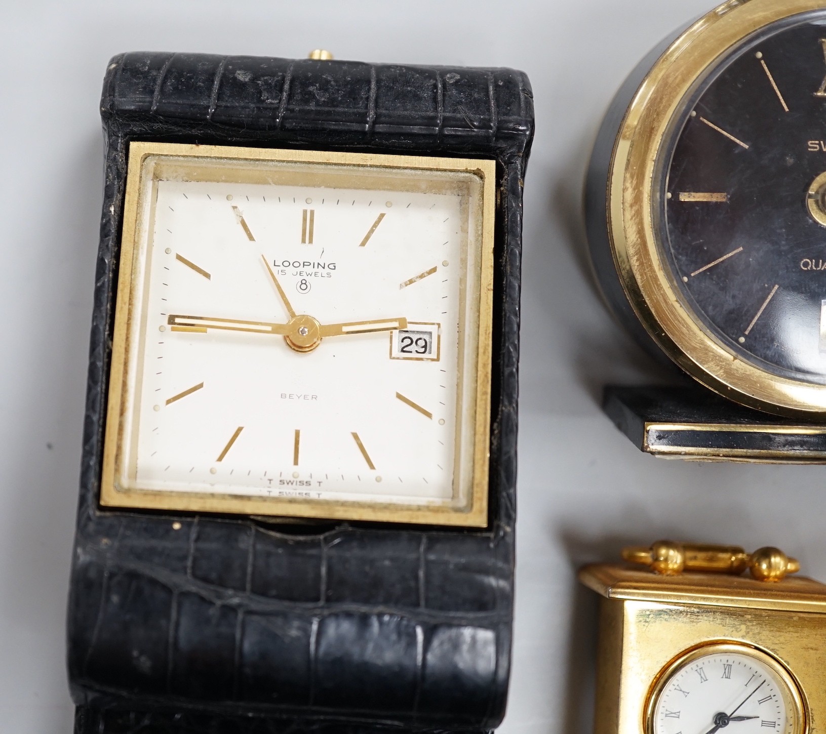 A Halcyon Days Harrods paperweight, a Halcyon Days timepiece and three other timepieces